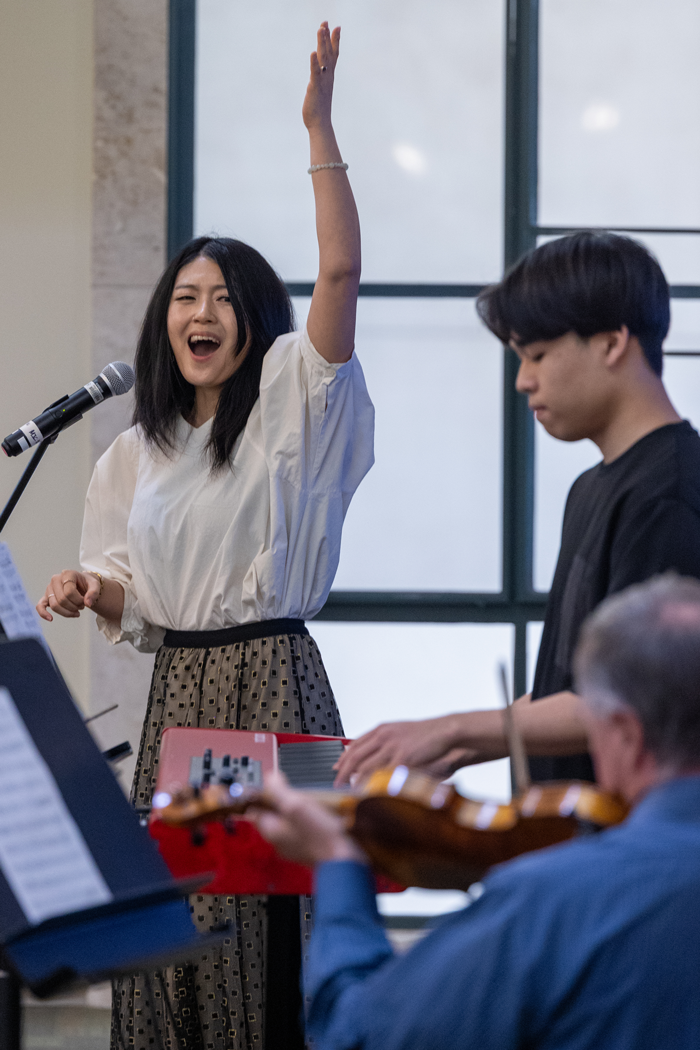 Geoff Westropp, on violin, Gloria Takahashi, and Hiroki Iwasa, on keyboard, perform during a pre-symposium event.