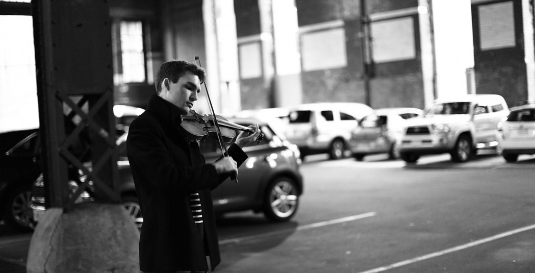 Alexi Kenny playing violin in parking garage