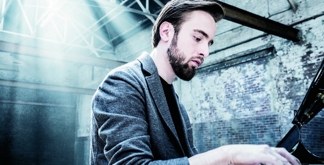Daniil Trifonov sitting with hand on piano