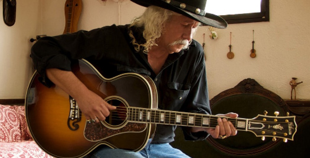 Arlo Guthrie playing guitar