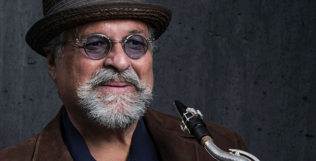 joe lovano wearing a hat and glasses and holding sax