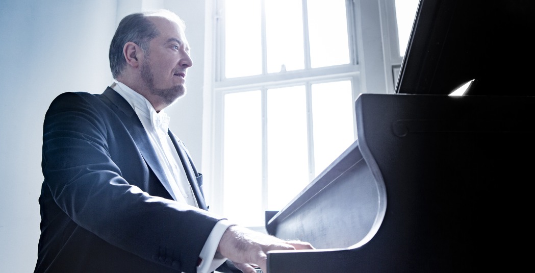 Man in dark suit playing piano