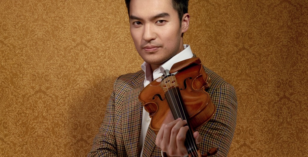 Man in brown suit standing with violin