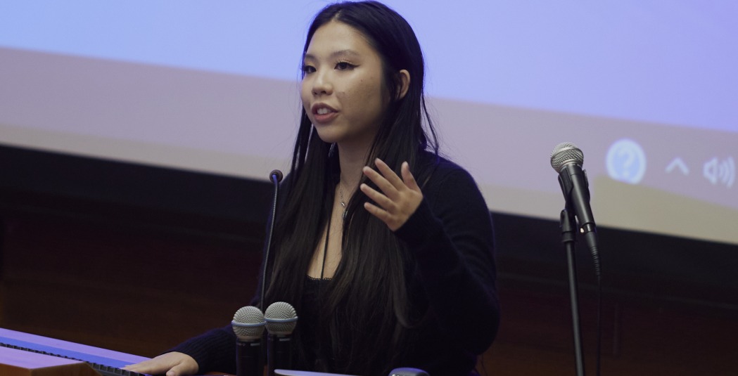 A SIGS Summer Program participant stands at a podium and gives a speech