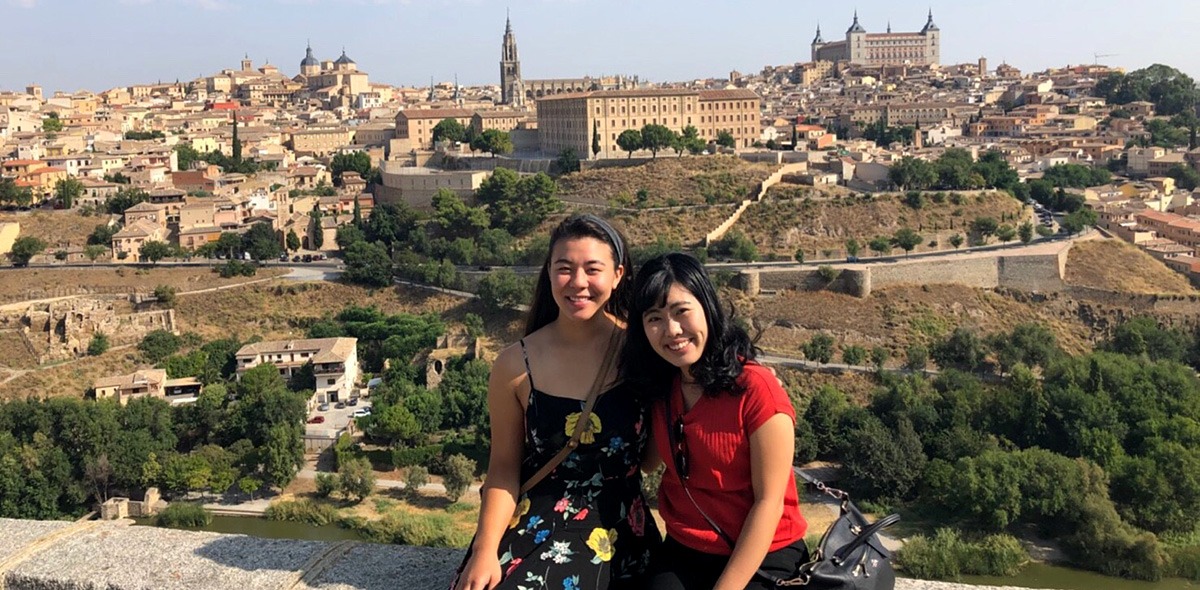 Two students in front of cityscape in Valencia, Spain