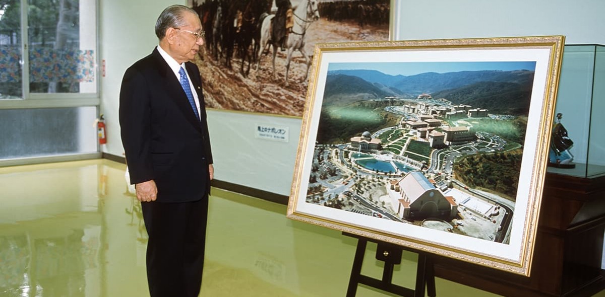 Daisaku Ikeda looks at large photo of the plans for the SUA Aliso Viejo campus