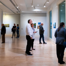 Various gallery attendees view different pieces of the art installations in Founders Gallery.