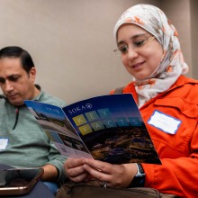 A man and a woman read information about SUA from a brochure during College Night