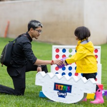 A student helps a child with Connect 4 during the 2025 Homecoming event