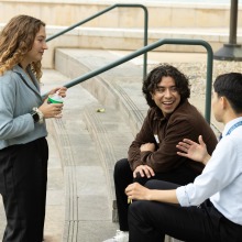 Three people talk while on campus during the SUA 2025 Homecoming event