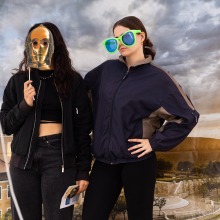 Two students pose with props in the photobooth during the 2025 Homecoming event