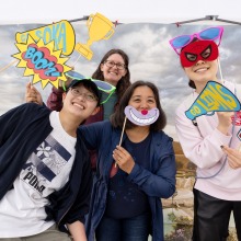 People pose with props at a photobooth during 2025 Homecoming