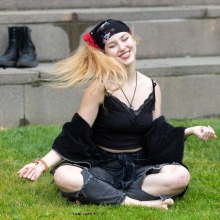 A girl sitting cross-legged flips her hair as she dances during the 2025 Homecoming Event