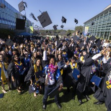 The Class of 2025 throw their graduation caps in the air in celebration.