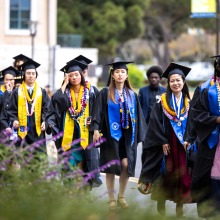 Graduates walk to the Performing Arts Center before commencement.