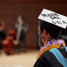 A masked graduate's hat reads "Made in SUA"