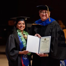 President Ed Feasel poses with the graduate he presented the Founder's Award to