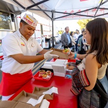 An SUA student gets her meal from the In-N-Out employee during SUA's annual Welcome Back Community Event 