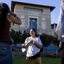 A photographer takes a photo of a female student competitor before one of the activities as she stands in front of the library.