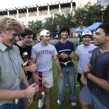 A group of male students smile as they gameplan for their upcoming activity.