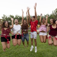 A group of students jump in the air in celebration after one of the activities during the Welcome Back event.