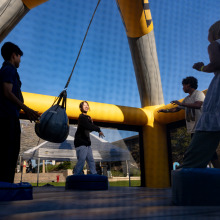 Four students participate in an inflatable game during the welcome back event.