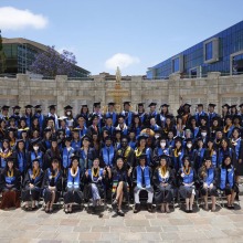 The Class of 2022 graduates pose in front of the Peace Lake Travertine Wall 