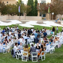 The Class of 2026 sit at circular white tables on the Campus Green during the Welcome Reception