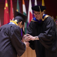 Kentaro Shintaku, recipient of the 2023 Founders Award, bows to President Feasel while accepting the award.