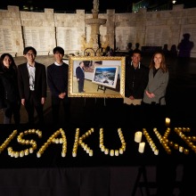 Students stand in front of Daisaku Ikeda memorial during a candlelit vigil
