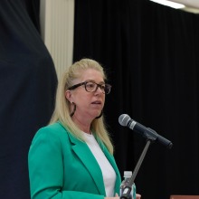 A woman speaks into a microphone during the symposium