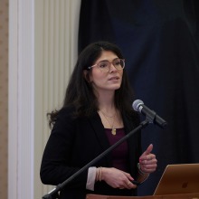 A woman speaks into a microphone during the symposium