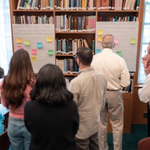 Conference attendees place sticky notes on two larger poster boards to signify their choice between two items.