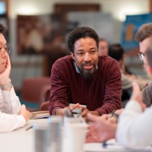 Four men listen intently during a group discussion.