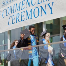 Graduates walk out of the Performing Arts Center after commencement.
