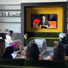 Students sit on a green couch and grey chairs to watch an international film in the Global Language and Culture Center