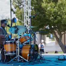 The Nandos drummer is drumming in sunglasses on stage at the festival