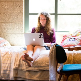 Student in residence hall working on laptop