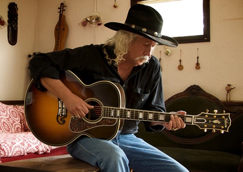 Arlo Guthrie playing guitar