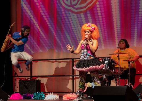 Three performers onstage playing instruments in costume