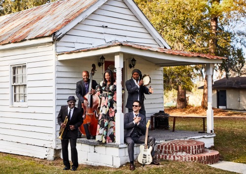 Artists sitting on porch of house