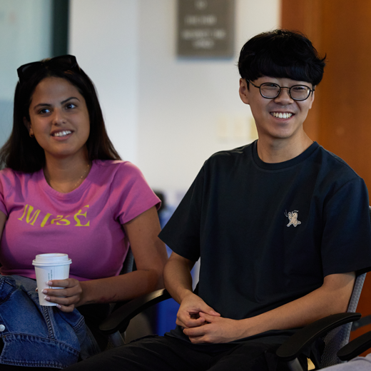 Two grad students sit in class.
