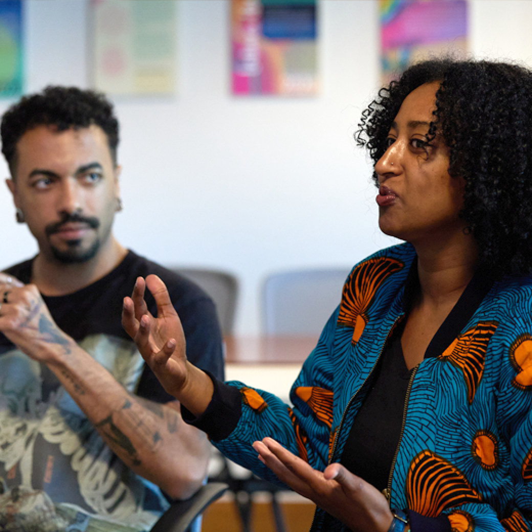Two graduate students participate in a discussion during class.