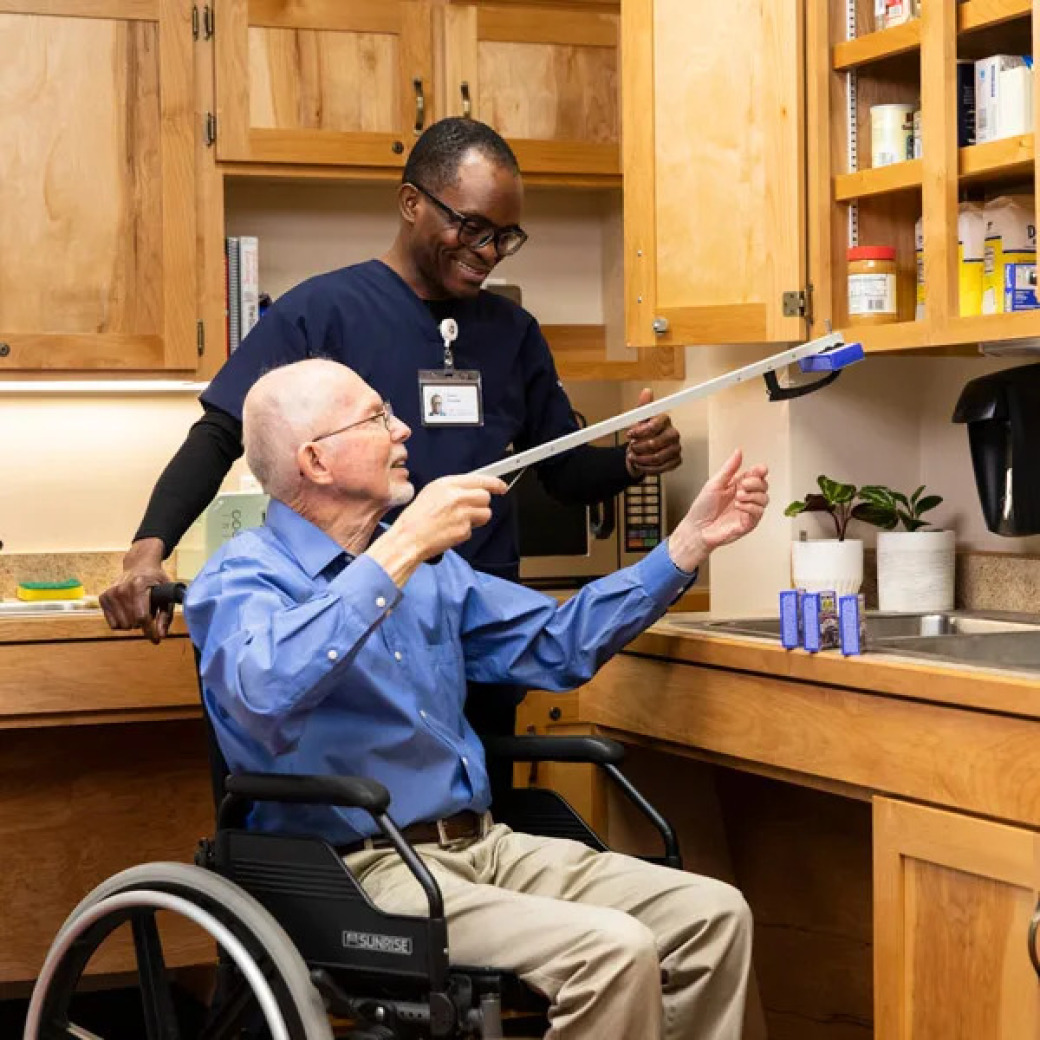 An OT is helping an elderly sitting on the wheelchair