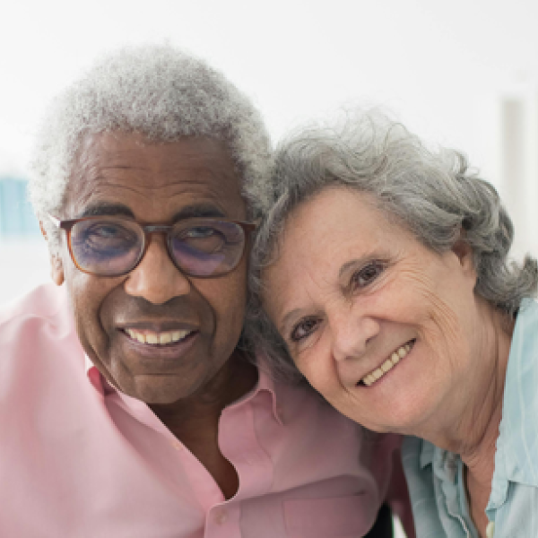 Two happy seniors sit together and smile
