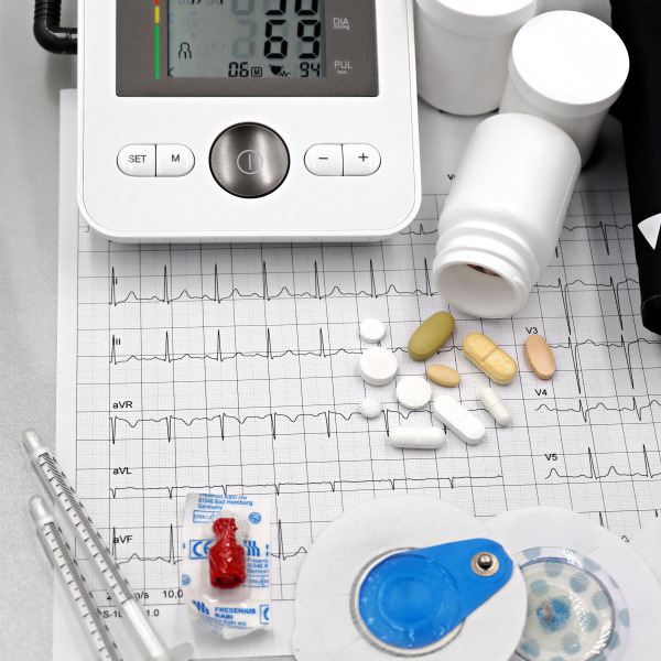 Blood pressure monitor, pills, syringes, and ECG printout
