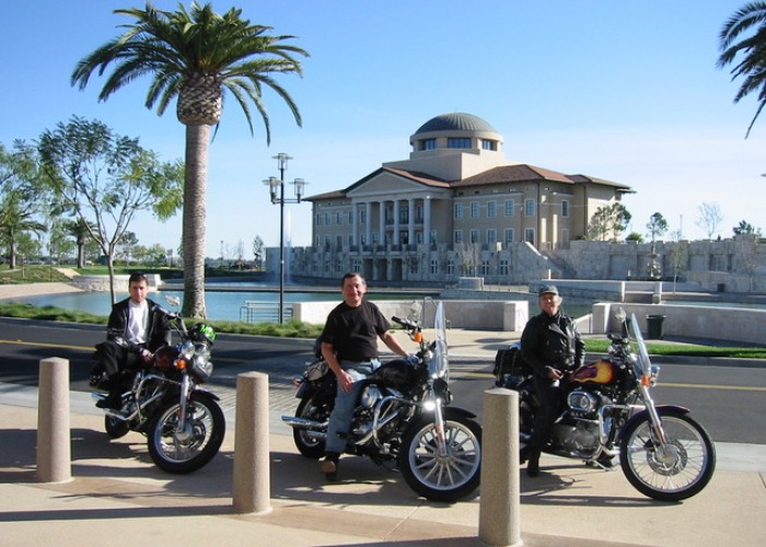 Three men sitting on motorcycles with Peace Lake in background