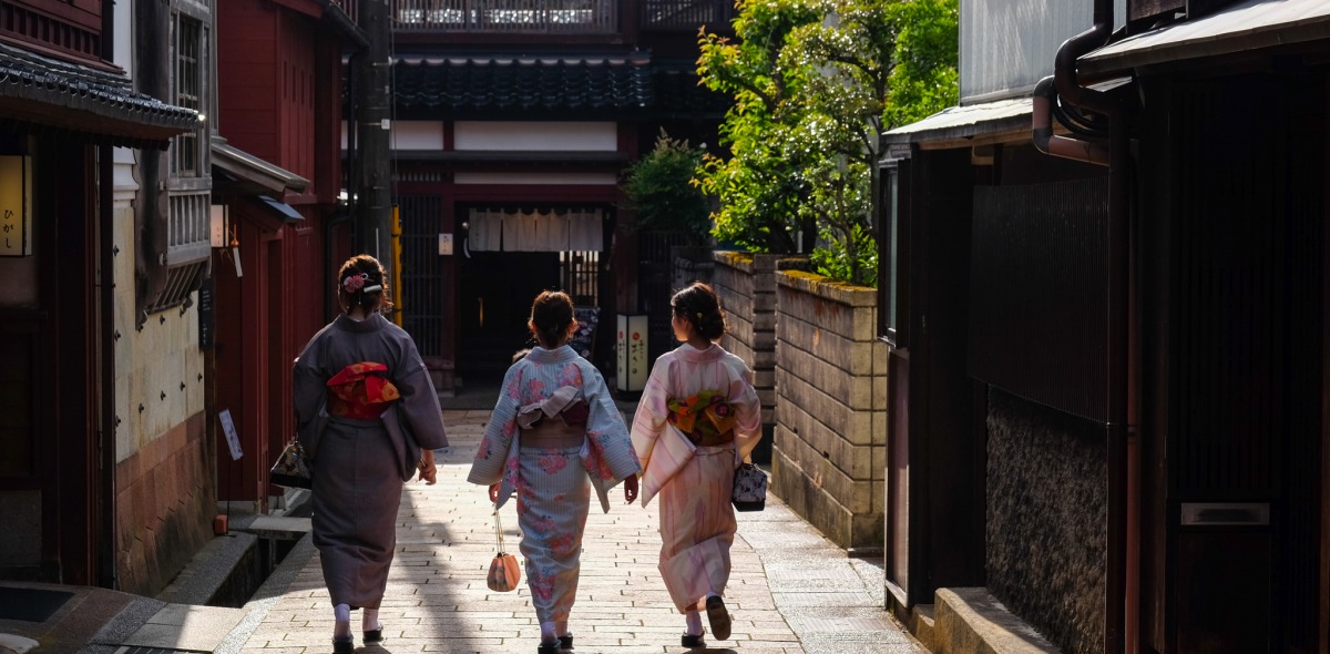 A picture of three women walking down the street. 