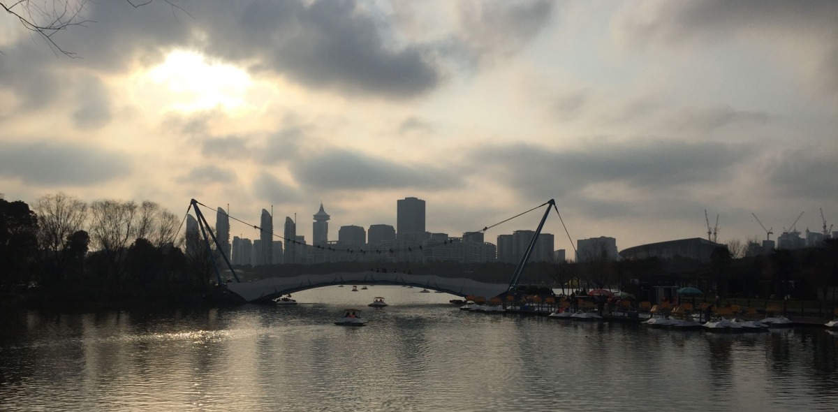 The sun rising behind buildings in Shanghai. 