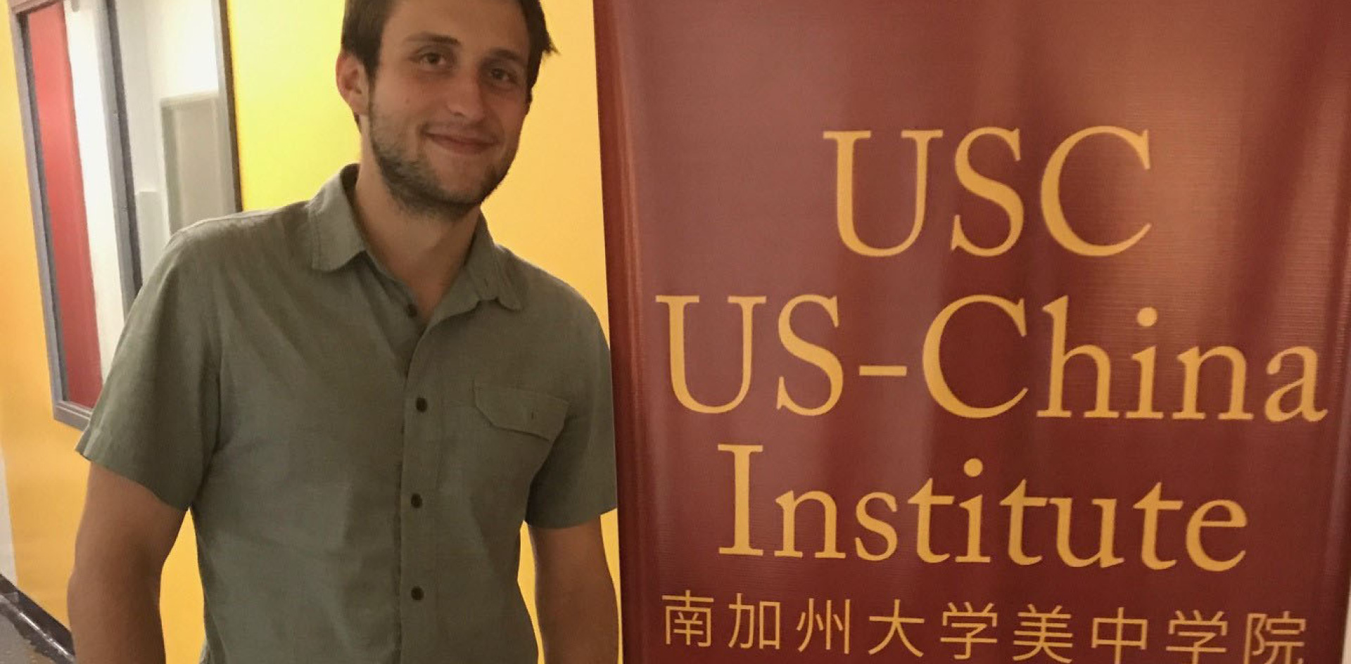 Student standing by a sign. 